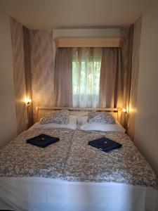a bedroom with a bed with two towels on it at Varázskuckó Apartman in Sümeg