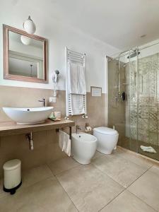 ein Badezimmer mit Waschbecken, Toilette und Dusche in der Unterkunft Itria Modica in Modica