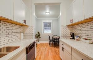 a kitchen with white cabinets and a table in it at Cute Downtown Stay near Toyota Center & Midtown in Houston