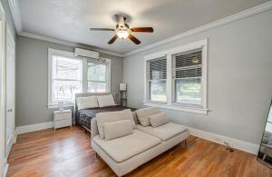 a bedroom with a bed and a couch and a ceiling fan at Cute Downtown Stay near Toyota Center & Midtown in Houston