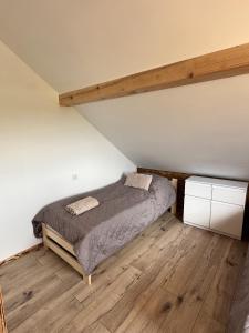 a bedroom with a bed and a wooden floor at Agroturystyka Rzepedka - Szarówka in Rzepedż +8 photos