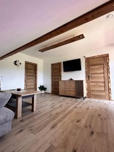a living room with a table and a flat screen tv at Agroturystyka Rzepedka - Szarówka in Rzepedż