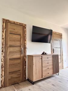 a room with a wooden door and a television on a wall at Agroturystyka Rzepedka - Szarówka in Rzepedż
