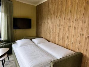 a bed in a room with a wall with a television at Flakstad beach house Silo B in Vareid