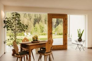 a dining room with a table and chairs and a large window at New - Penthouse Zirm Untermairhof in Selva dei Molini