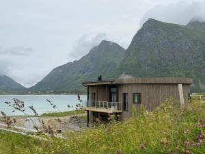 a house on the beach with mountains in the background at Flakstad beach house Silo B in Vareid