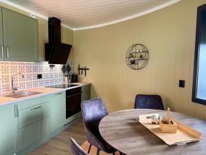 a kitchen with a table and chairs and a sink at Flakstad beach house Silo B in Vareid