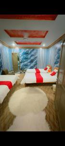 a bedroom with two beds and a large rug at Ruby Bahrain Hotel in Mingāora