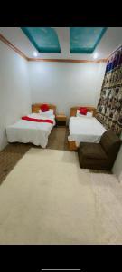 a living room with two beds and a couch at Ruby Bahrain Hotel in Mingāora
