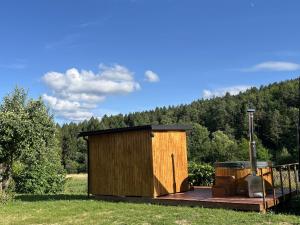 a wooden building with a grill on a deck at Agroturystyka Rzepedka - Szarówka in Rzepedż