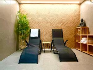 a waiting room with three black chairs and a table at Apartmány Perninský Dvůr in Pernink
