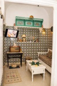 a living room with a couch and a table at El Hamra Maison Traditionnelle in Mahdia
