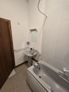 a bathroom with a bath tub and a sink at The Garve Flats in Garve +17 photos