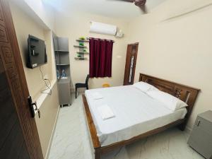 a bedroom with a bed and a television in it at Kavitha Residency in Virudunagar