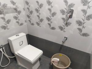 a bathroom with a toilet and a phone on the wall at Kavitha Residency in Virudunagar