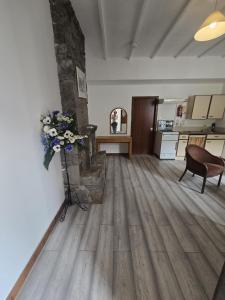 a living room with a stone fireplace and flowers on the wall at The Garve Flats in Garve