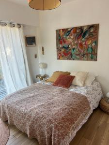 a bedroom with a bed and a painting on the wall at Les mimosas in Tosse