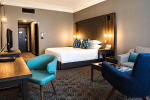 a hotel room with a bed and two chairs at Fiesta Royale Hotel in Accra