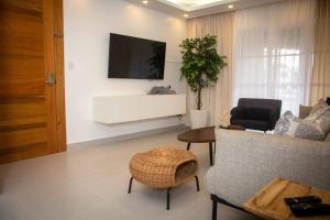 a living room with a couch and a tv on a wall at Condo in Puerto Plata in San Felipe de Puerto Plata