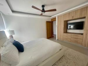 a bedroom with a bed and a flat screen tv at Condo in Puerto Plata in San Felipe de Puerto Plata