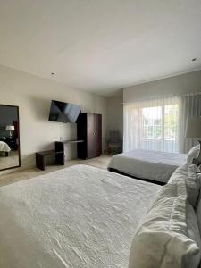 a hotel room with two beds and a flat screen tv at Grann Hotel in Ciudad Valles +20 photos