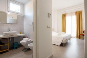 ein Badezimmer mit Bett, Toilette und Waschbecken in der Unterkunft Sa Pasadina in Àrbatax + 65 Fotos