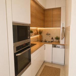 a kitchen with white cabinets and a black microwave at Garden lux 1 in Belgrade