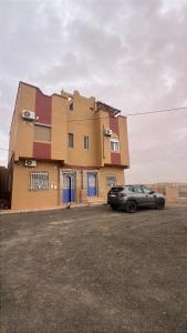 a car parked in front of a building at Merzouga Desert Apartment in Merzouga