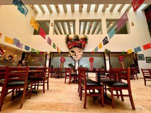 a restaurant with wooden tables and chairs and a mask at Grann Hotel in Ciudad Valles