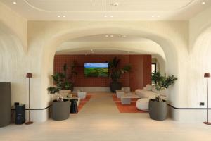 a lobby with white furniture and plants in a building at Safin Hotel & Spa in Vlorë +101 photos