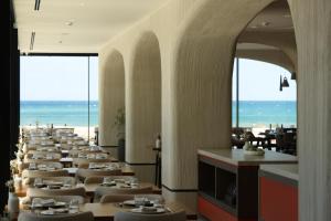 a row of tables in a restaurant with the beach at Safin Hotel & Spa in Vlorë