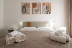 ein Schlafzimmer mit weißen Handtüchern auf einem großen Bett in der Unterkunft Sa Pasadina in Àrbatax