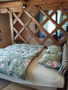 a bed in a log cabin with pillows on it at Hillside Bio Resort Delux Apartments in Šešče pri Preboldu +102 photos