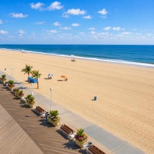 a beach with chairs and umbrellas and the ocean at Boardwalk One in Ocean City