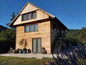a large wooden house with a staircase in front of it at Hillside Bio Resort Delux Apartments in Šešče pri Preboldu