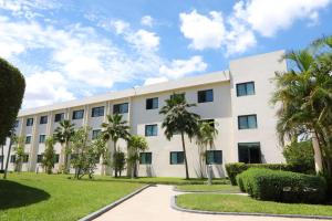 a white building with palm trees in front of it at Fiesta Royale Hotel in Accra