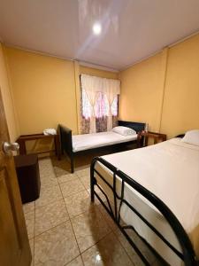 a room with two beds and a window at Casa Colibrí Nature, Pool and Tranquility in Sarapiquí