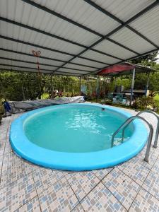 a large swimming pool with an overhead roof at Casa Colibrí Nature, Pool and Tranquility in Sarapiquí