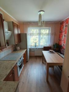 a kitchen with a wooden table and a table sidx sidx sidx at Weekend Home in Visaginas +10 photos