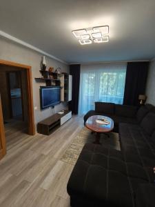 a living room with a black couch and a table at Weekend Home in Visaginas