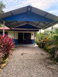 a blue and white building with a roof at Casa Colibrí Nature, Pool and Tranquility in Sarapiquí