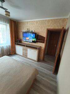 a bedroom with a bed and a flat screen tv at Weekend Home in Visaginas