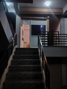 a staircase in a building with a pink door at Swarna Lodge in Badami