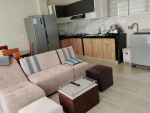 a living room with a couch and a kitchen at Casa Sol in Tingo María