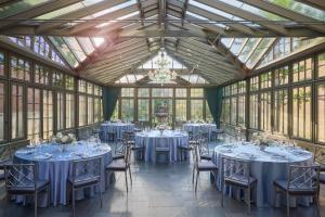 a room with tables and chairs in a conservatory at Royal Park Hotel in Rochester