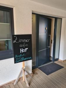 a sign in front of a building with a door at Zimmer auf'm Hof in Gerabronn