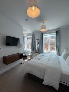 a bedroom with a large bed and a flat screen tv at Nova Rooms in Thirsk