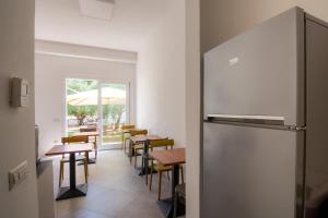 ein Esszimmer mit Tischen und einem Kühlschrank in der Unterkunft Sa Pasadina in Àrbatax