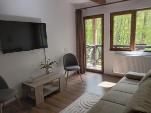 a living room with a couch and a tv on a wall at Casa Sf Nicolae in Sinaia