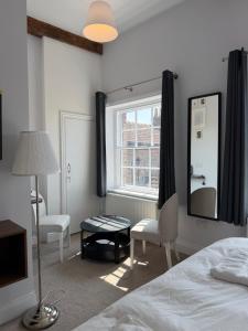 a bedroom with a bed and a mirror and a window at Nova Rooms in Thirsk